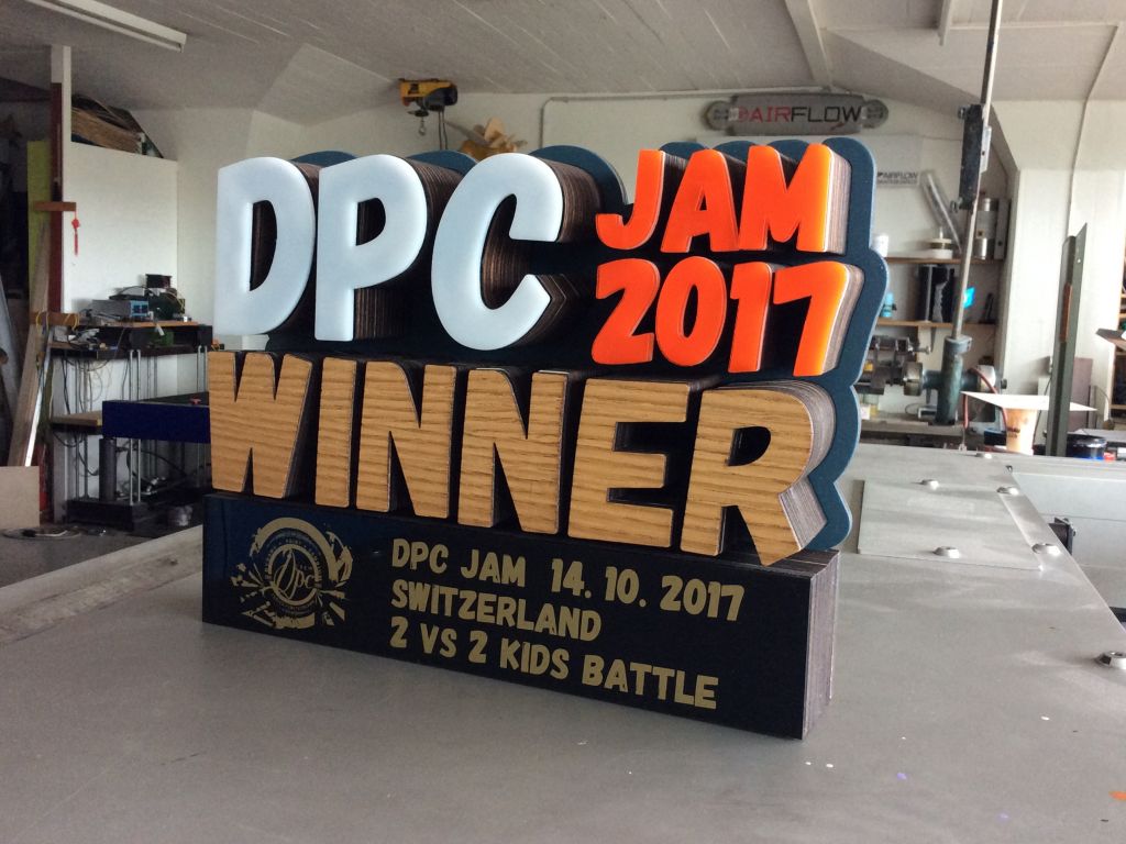 Chris Hart GmbH Siebdruck und Beschriftungen Zürich: Fräsarbeiten / Laser cut  - Pokal aus Holz und Plexiglas inkl. goldiger Siebdruck  